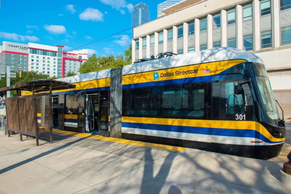 White, yellow, and blue Dallas Streetcar at station in downtown Dallas, Texas.
